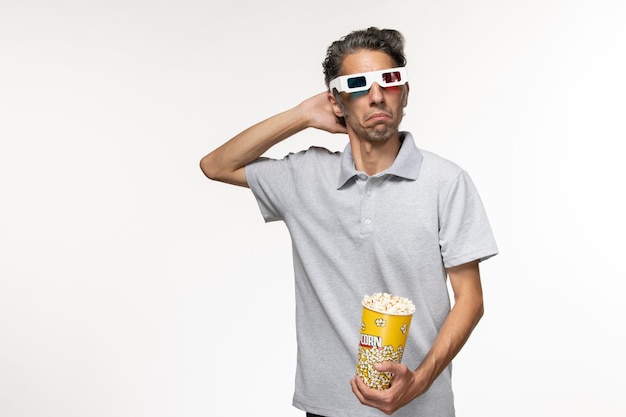 Front view young male holding popcorn and wearing d sunglasses on light white surface