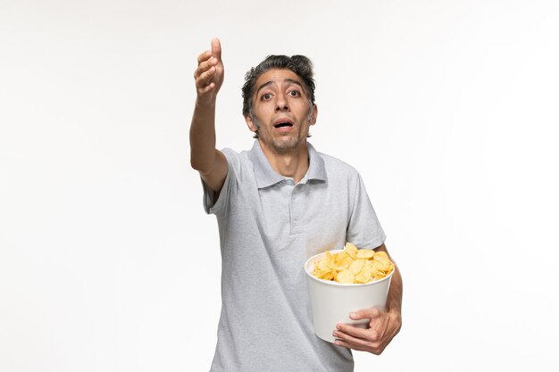 Front view young male holding potato chips on a white surface