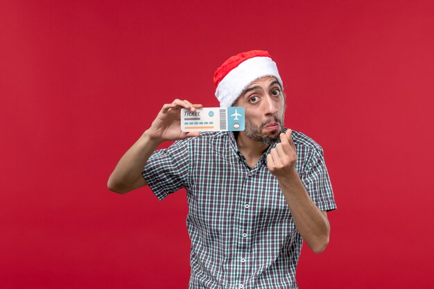 Front view young male holding ticket on red background