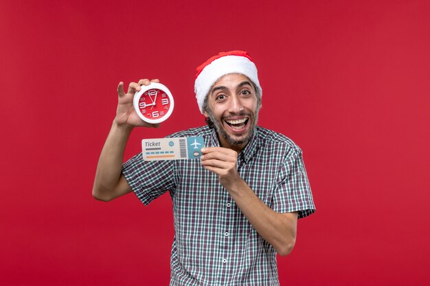 Front view young male holding ticket with clock on red background