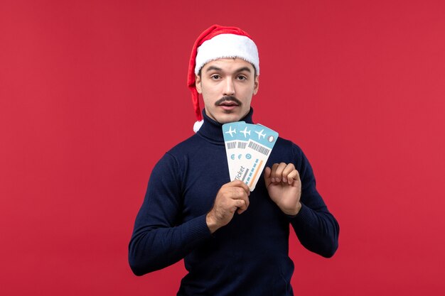 Front view young male holding tickets on red background