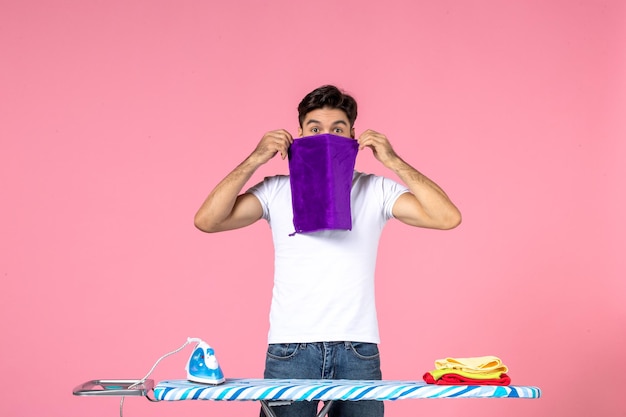 Free photo front view young male holding towel on a pink