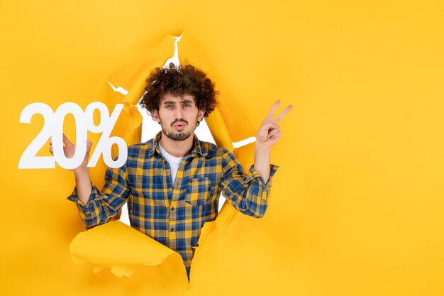 Front view young male holding writing on yellow background