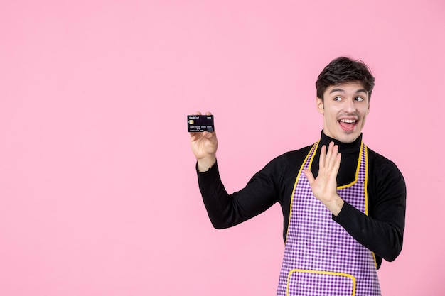 正面図ピンクの背景色の銀行カードを保持している岬の若い男性主な職業水平料理料理労働者制服の仕事