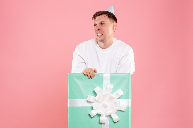 Front view young male inside present displeased on pink background