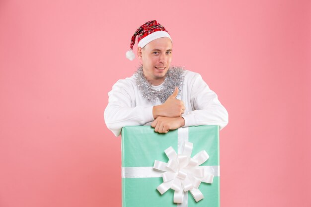 Front view young male inside present smiling on pink background