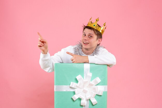 Front view young male inside present with crown on pink background