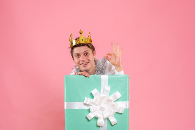 Front view young male inside present with crown on pink desk