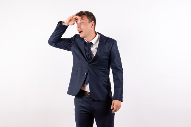 Front view young male looking at distance in classic strict suit on white background