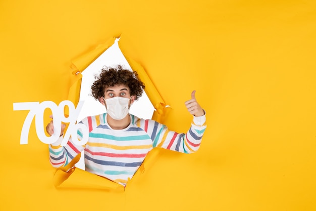 노란색 판매 쇼핑 컬러 covid-photos 바이러스 건강 전염병에 대한 글을 들고 마스크를 쓴 전면 보기 젊은 남성