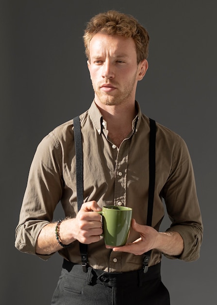 Front view young male model holding a cup of coffee