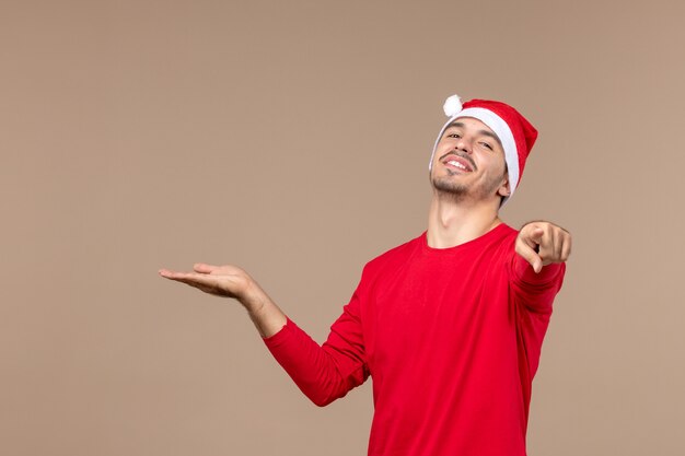 Вид спереди молодой мужчина, указывая на коричневый фон мужской цвет эмоции праздник