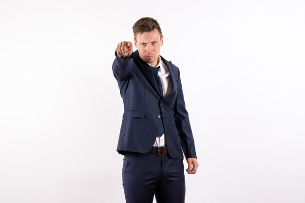 Front view young male pointing at you in classic strict suit on white background