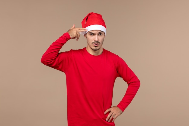 Front view young male posing on brown background christmas holiday emotion
