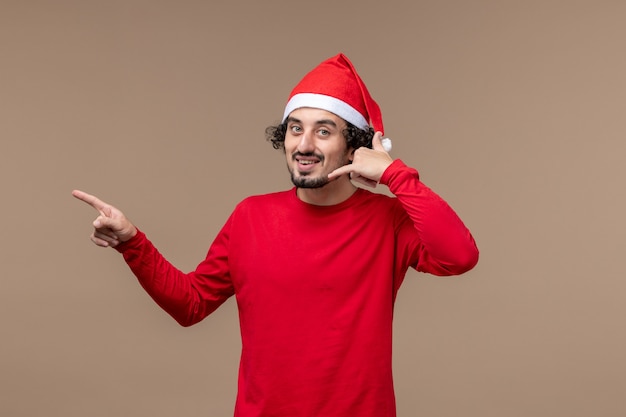 Front view young male posing on a brown background emotions christmas holiday