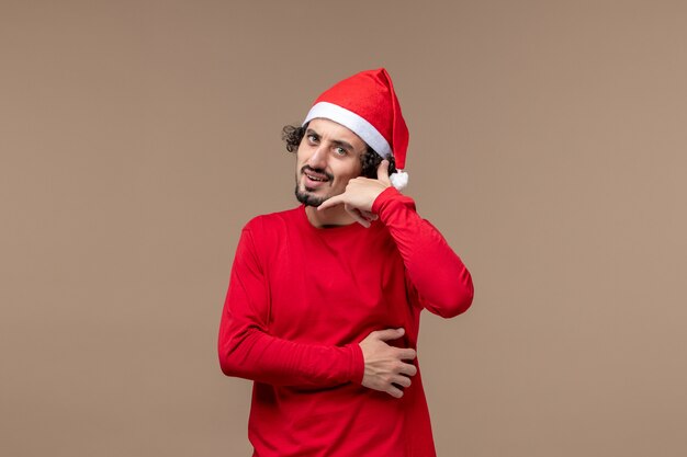 Front view young male posing on brown background emotions christmas holiday