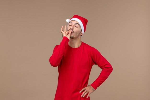 Front view young male posing on brown background holiday christmas emotion