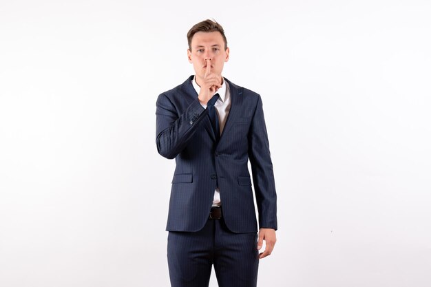 Front view young male posing in classic strict suit on a light white background