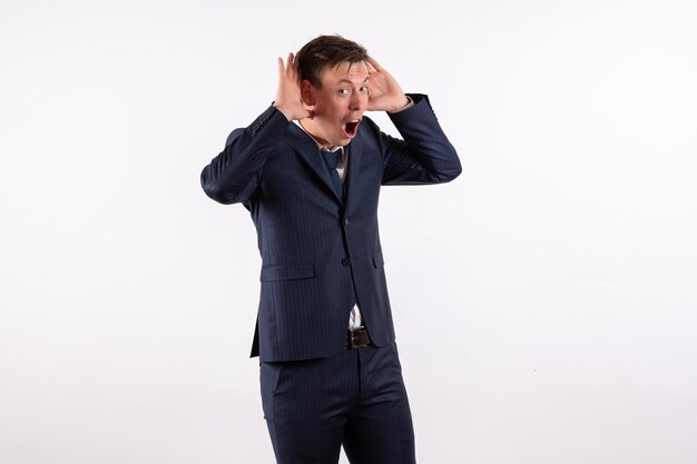 Front view young male posing in classic strict suit on white background