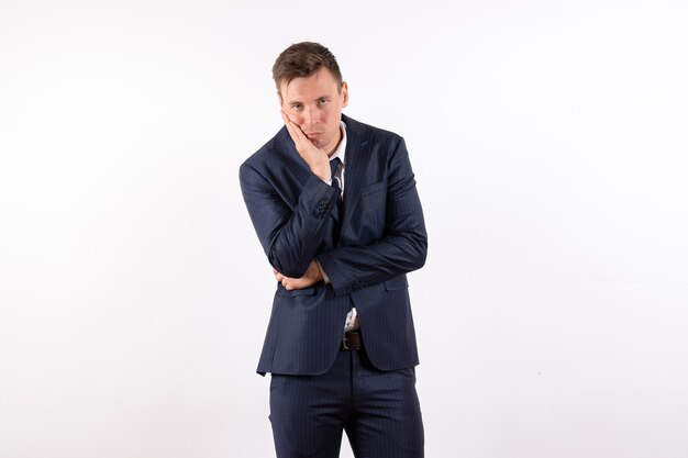 Front view young male posing and waiting in classic strict suit on white background