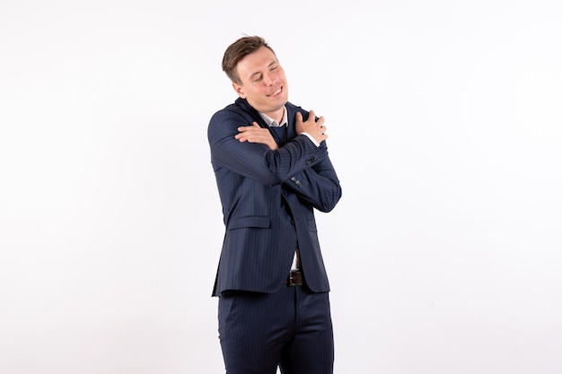 Front view young male posing with delighted expression in classic strict suit on white background