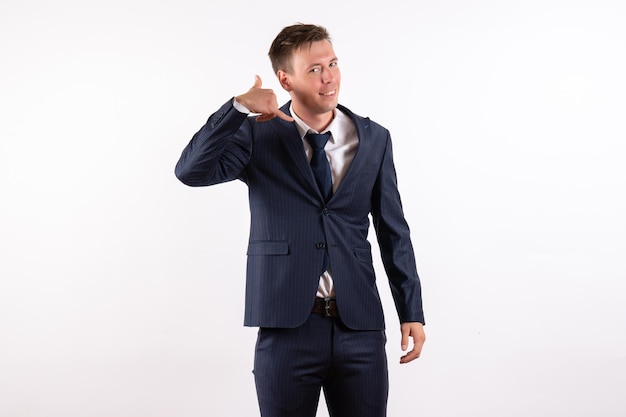 Front view young male posing with smile in classic strict suit on white background