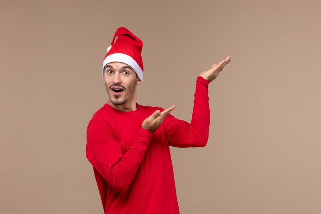 Front view young male posing with surprised face on a brown background emotion holiday christmas