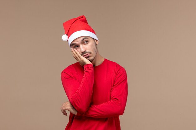 Front view young male posing with thinking face on a brown background emotion holiday male