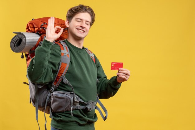 Front view young male preparing for hiking holding bank card
