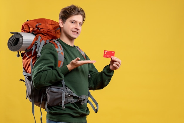 Front view young male preparing for hiking holding red bank card