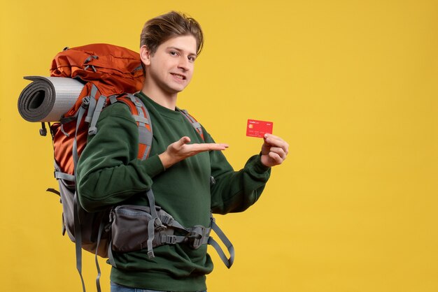 Front view young male preparing for hiking holding red bank card