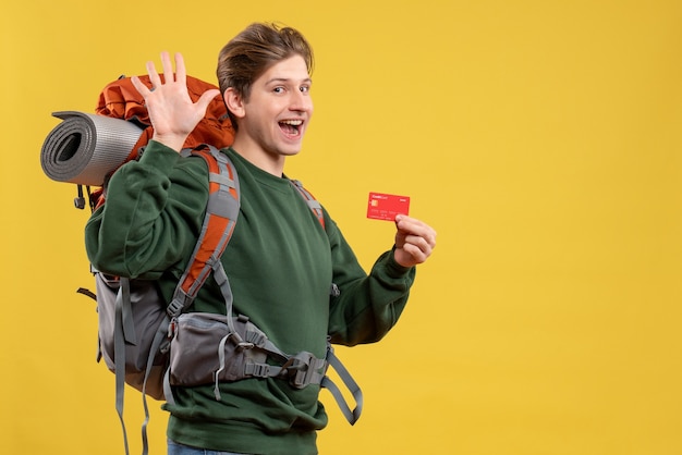 Front view young male preparing for hiking holding red bank card