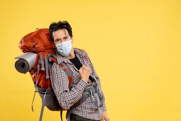 Front view young male preparing for hiking in mask on the yellow 