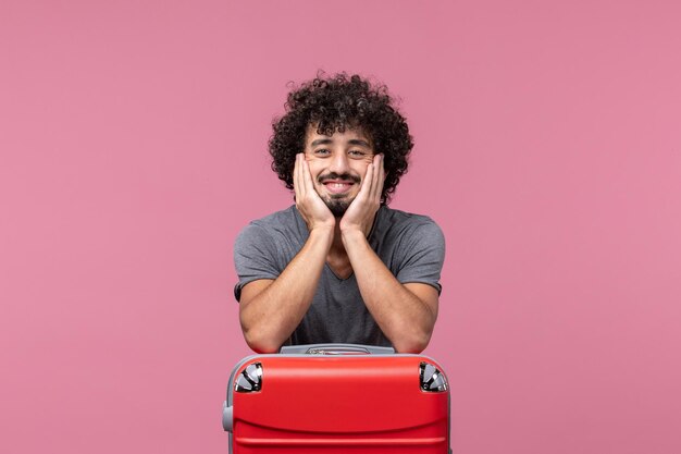 Front view young male preparing for trip with bag smiling on pink space