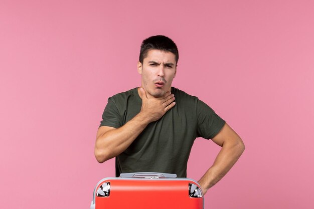 Front view young male preparing for vacation and coughing on pink space