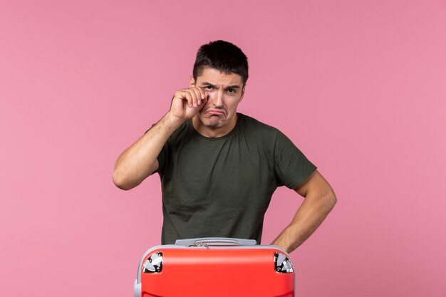 Front view young male preparing for vacation and crying on the pink space