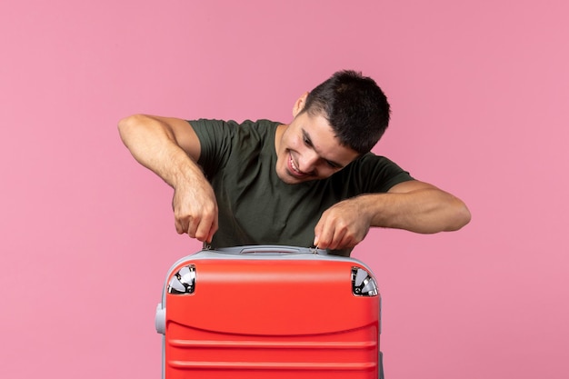 Free photo front view young male preparing for vacation and feeling happy on light pink space