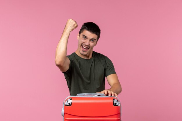 Front view young male preparing for vacation and feeling happy on a pink desk