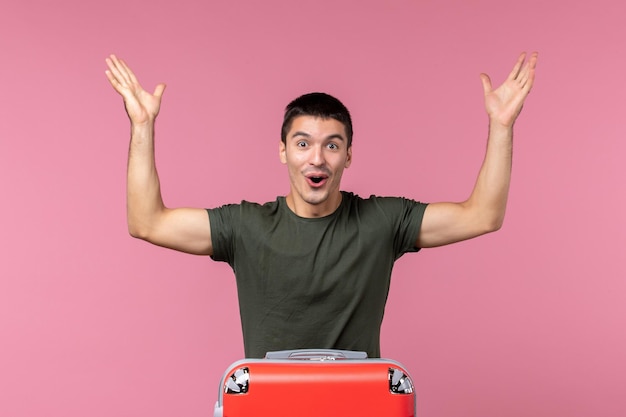 Front view young male preparing for vacation and feeling happy on pink space