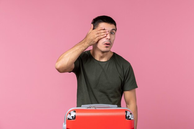 Front view young male preparing for vacation on pink space