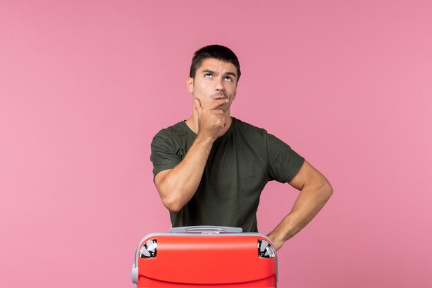 Front view young male preparing for vacation and thinking about something on pink space