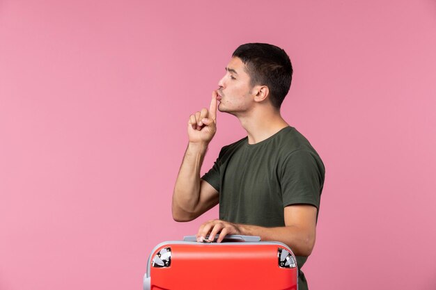 Front view young male preparing for vacation with bag on pink space