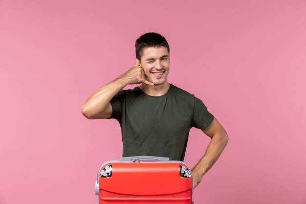 Front view young male preparing for vacation with big bag on the pink space