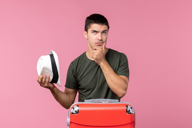 Front view young male preparing for vacation with big bag thinking on pink space