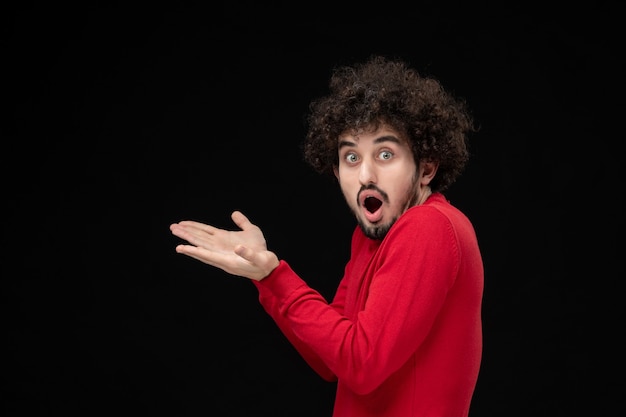 Foto gratuita vista frontale del giovane maschio in camicia rossa sul muro nero