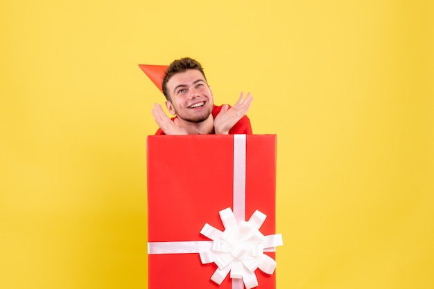 Front view young male in red shirt inside present box