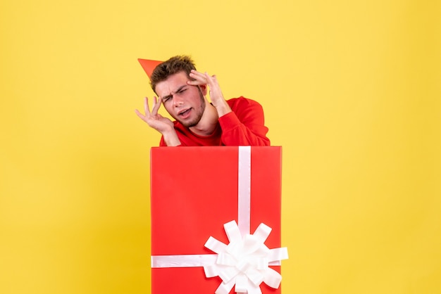 Front view young male in red shirt inside present box