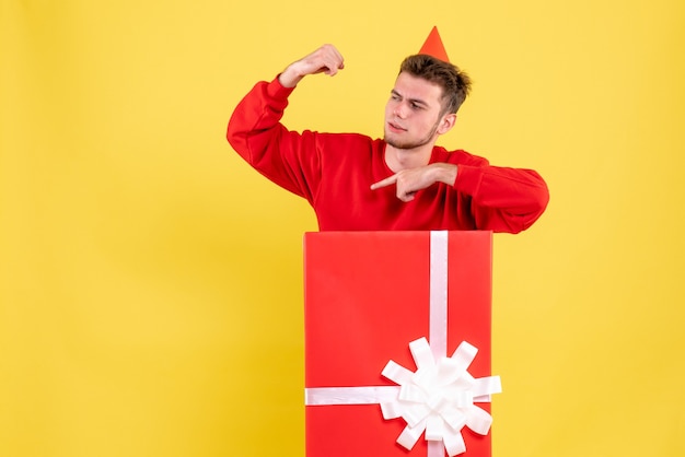 Front view young male in red shirt inside present box