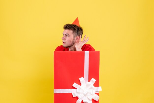 Front view young male in red shirt inside present box