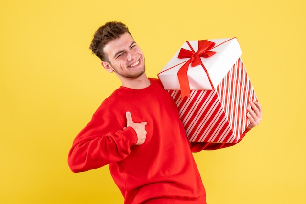 Front view young male in red shirt with christmas present